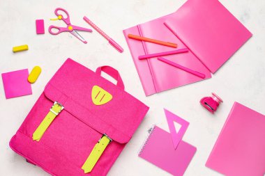 Beyaz arkaplanda okul çantası ve kırtasiye malzemesi