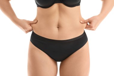 Beyaz arka planda selülit sorunu olan genç bir kadın.