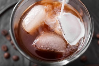 Bardaktaki soğuk kahveye süt dök, yakından.