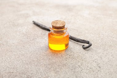 Açık arkaplanda aromatik vanilya özü bulunan şişe