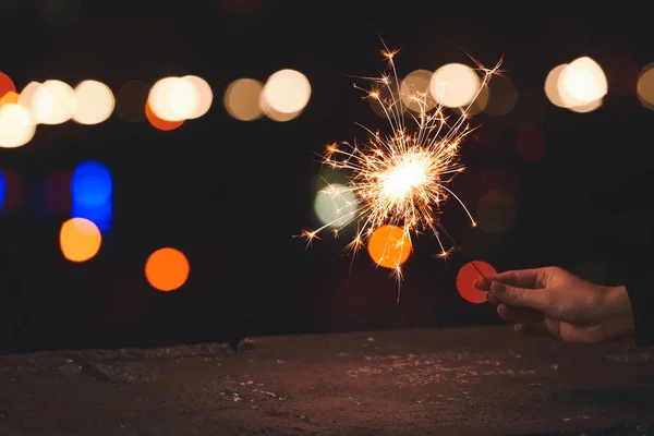 Mão Com Espumante Natal Fundo Escuro Com Luzes Embaçadas — Fotografia de Stock