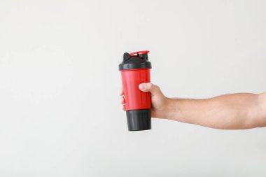 Hafif arka planda protein karışımı olan bir erkek el.