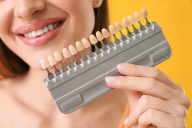 Diş rengi örnekleriyle güzel bir genç kadın, yakın plan.