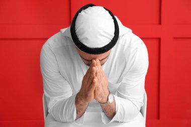 Renkli arka planda namaz kılan Arap adam