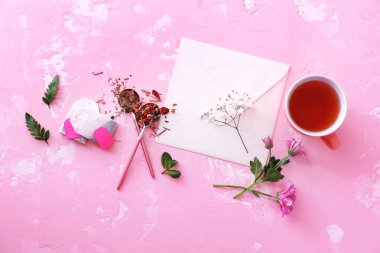 Renkli arka planda sıcak çay ve zarf kompozisyonu