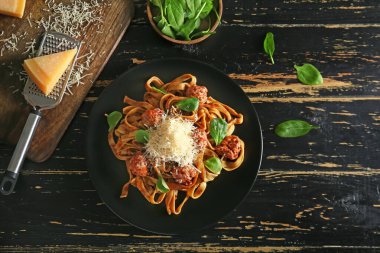 Koyu masada lezzetli makarna ve peynirli tabak.