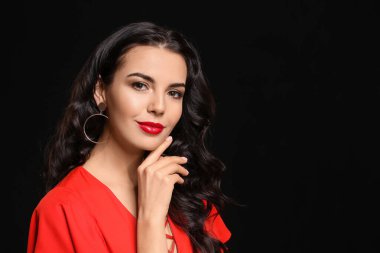 Siyah arka planda güzel makyajlı genç bir kadın.