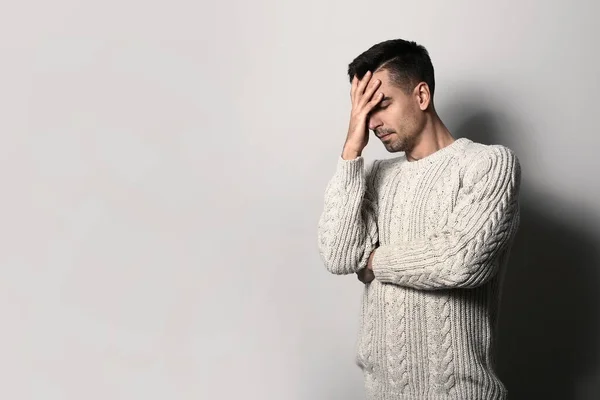 Depressed young man on light background