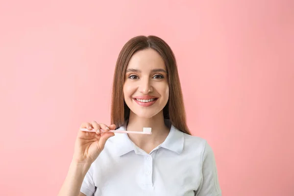 色の背景に美しい笑顔と歯ブラシを持つ若い女性 — ストック写真