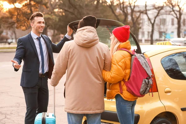 Taxi Driver Aiutare Giovane Coppia Mettere Loro Bagagli Nel Bagagliaio — Foto Stock