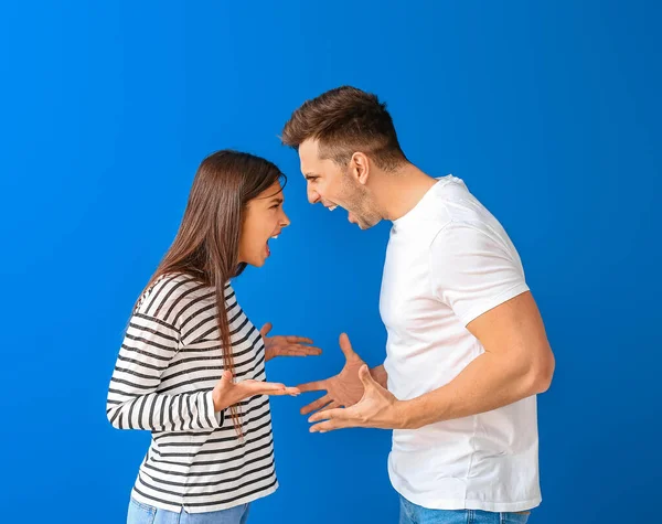 Pareja Joven Discutiendo Sobre Fondo Color —  Fotos de Stock