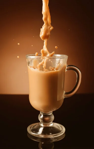 Wlewanie Kawy Mlekiem Szklanej Filiżanki Ciemnym Tle — Zdjęcie stockowe