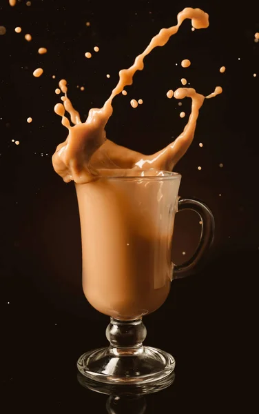 暗い背景にガラスカップでコーヒーのスプラッシング — ストック写真