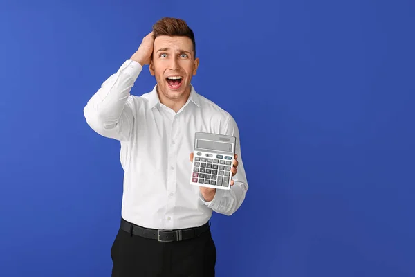 Hombre Joven Estresado Con Calculadora Sobre Fondo Color — Foto de Stock