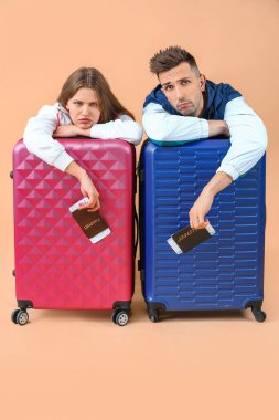 Arka planda bavulu olan yorgun turistler.