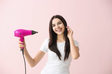 Arka planda saç kurutma makinesi olan güzel bir kadın.