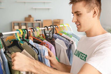 İçerideki fakir insanlar için giysi taşıyan bir gönüllü.