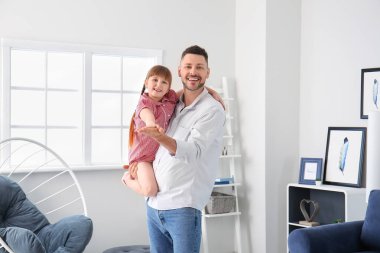 Father and his little daughter dancing at home