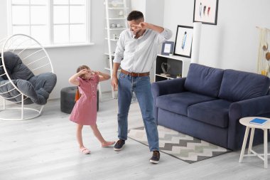 Father and his little daughter dancing at home