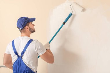 Erkek ressam odada tamirat yapıyor.