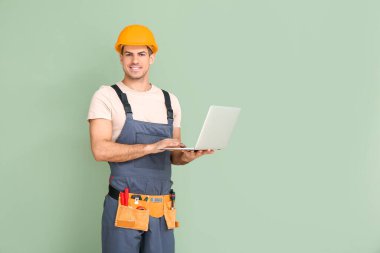 Renkli dizüstü bilgisayarı olan yakışıklı bir erkek işçi