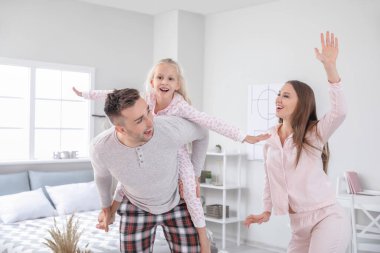 Happy family dancing in bedroom