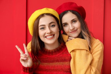 Renkli arka planda kalın kazaklı genç kadınlar