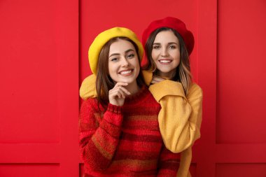 Renkli arka planda kalın kazaklı genç kadınlar