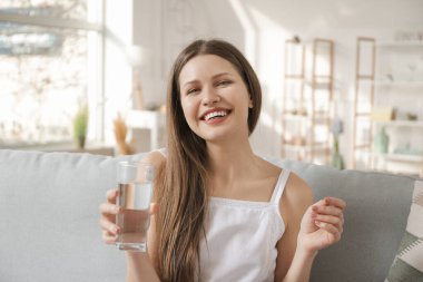 Evinde su içen güzel genç bir kadın.