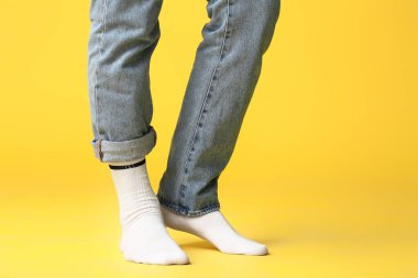 Çoraplı erkek bacakları ve renkli kot pantolon.