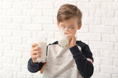 Beyaz arka planda sütü olan küçük çocuk.