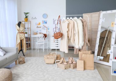 Modern giyinme odasının içinde şık kadın kıyafetleri var.