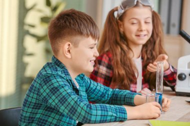 Sınıfta kimya dersinde küçük şirin çocuklar.