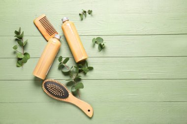 Ahşap arka planda bitkisel özlü şampuan, tarak ve fırça