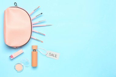 Makyaj malzemesi ve renk arkaplanlı bir şişe parfüm.