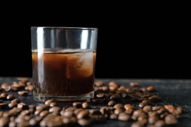 Koyu arkaplanda bir bardak buzlu kahve.