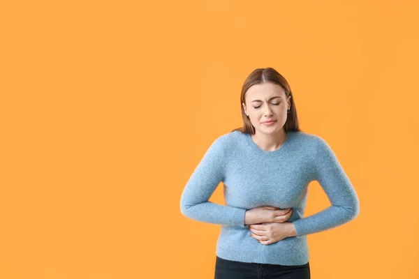 Mujer Joven Que Sufre Dolor Abdominal Fondo Color —  Fotos de Stock