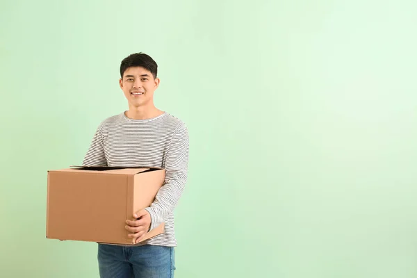 Asiatischer Mann Mit Bewegter Box Auf Farbigem Hintergrund — Stockfoto