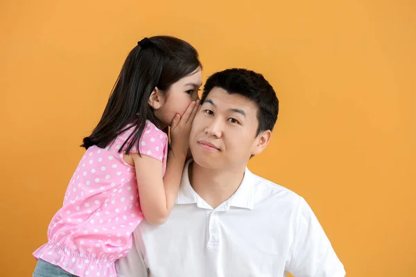 Liten Asiatisk Flicka Berättar Hemlighet För Sin Far Färg Bakgrund — Stockfoto