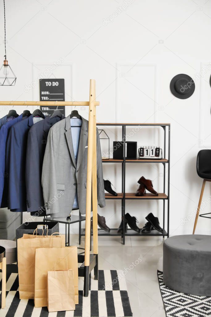 Interior of modern dressing room with stylish male clothes