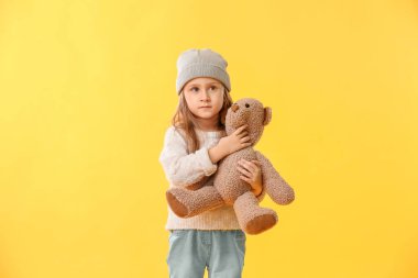 Renk arka plan üzerinde oyuncak ayı ile sevimli küçük kız