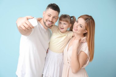 Aile renk arkaplanında selfie çekiyor