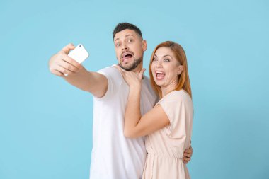 Couple taking selfie on color background