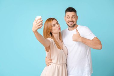 Couple taking selfie on color background