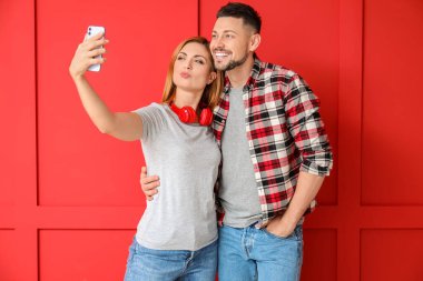 Couple taking selfie on color background