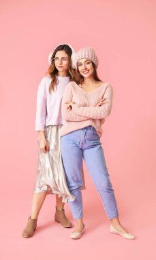 Renkli arka planda kalın kazaklı genç kadınlar