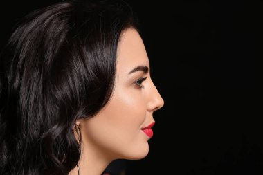 Siyah arka planda güzel makyajlı genç bir kadın.