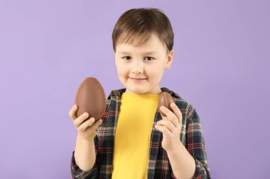 Renkli çikolatalı yumurtaları olan tatlı küçük bir çocuk.