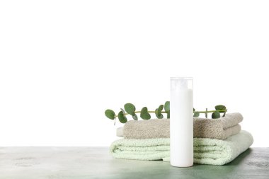 Masada beyaz arka planda şampuan ve havlular