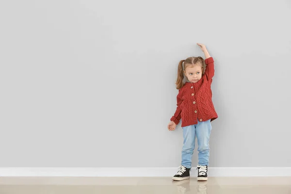 Menina Bonito Medindo Altura Perto Parede Cinza — Fotografia de Stock